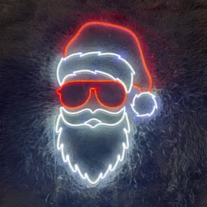 The Christmas LED Neon Sign artistically features a stylized Santa Claus face, complete with a red hat, sunglasses, and a white beard and mustache, all vividly displayed against a dark textured background.