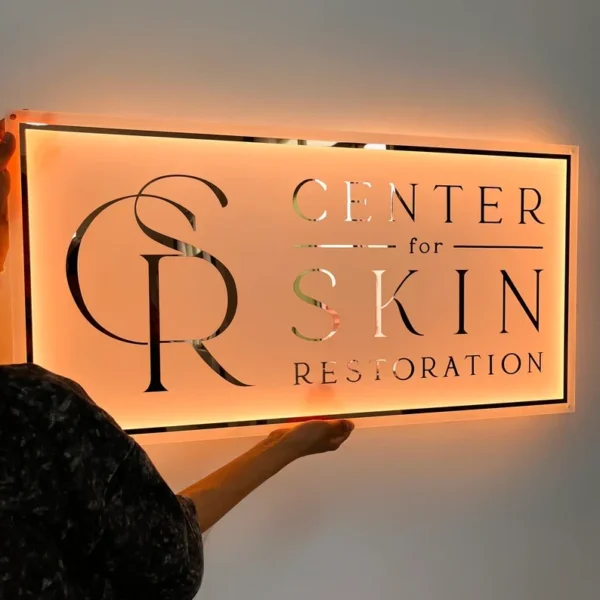 Elegant custom acrylic sign with illuminated design, perfect for nail salons or beauty centers, featuring the "Center for Skin Restoration" logo.