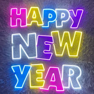 Colorful neon sign displaying "Happy New Year" in vibrant pink, yellow, blue, and white, perfect for festive celebrations.