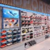 A shoe store display features various sneakers grouped into running, casual, and sports categories. A Full Color LED Digital Display Sign with WiFi & USB capabilities shows a sneaker image at the top left, enhancing the showcase with vibrant visuals.